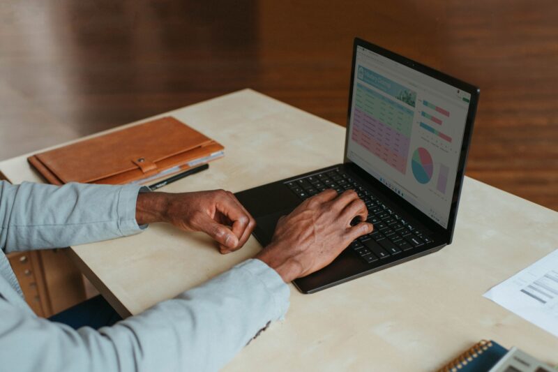 A man works on his laptop that displays graphs.